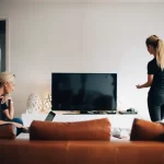 Vrouw kijkt samen met man tv met decoder in de woonkamer