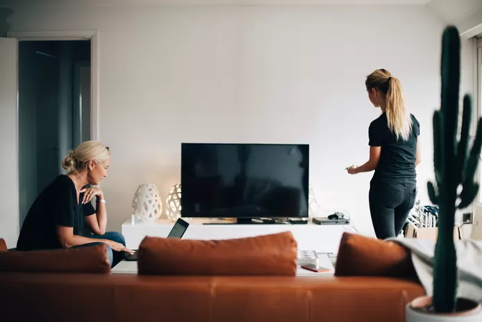 Vrouw kijkt samen met man tv met decoder in de woonkamer