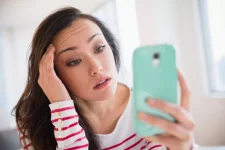 Vrouw frustreert zich omdat haar smartphone niet werkt door beperkte mobiele dekking.