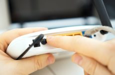 Vrouw installeert wifi-repeater bij haar thuis.