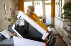 Vrouw pakt nieuwe tv uit die ze kocht bij Telenet voor Black Friday.