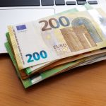 Stapel geld ligt op laptop