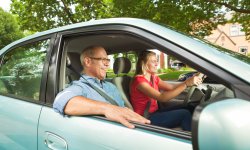 Dochter rijdt met de auto terwijl haar vader passagier is.