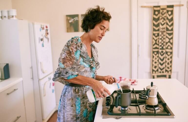 Huurder in keuken die melk inschenkt, een moment uit het dagelijks leven met vaste kosten