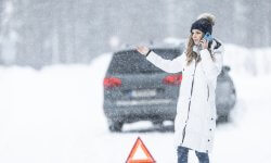 Vrouw heeft autopech op besneeuwde weg en belt pechverhelping
