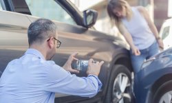 Man neemt foto van auto die tegen elkaar gebotst zijn