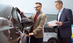 Man is onder de indruk van een auto die hij op het Autosalon ziet.