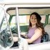 Vrouw rijdt rond in groene oldtimer.