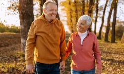 Ouder koppel wandelt in het bos tijdens de herfst